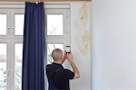 A contractor surveys damp and mould in a property