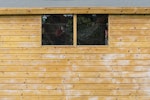 Close-up of a shed wall with Roxil Wood Protection Cream freshly applied. Still wet.