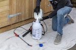 A contractor pouring Roxil Wood Protection Liquid into a pump-action pressure sprayer.