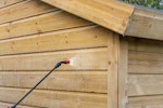 A contractor applying Roxil Wood Protection Liquid on a shed with a pump-action pressure sprayer. 4.