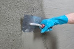 Drybase Universal Mortar being trowelled smooth after spray application onto a wall