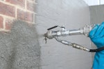 Drybase Universal Mortar being spray applied to a birck wall