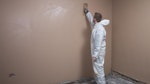 Applying a finishing skim coat on top of the plasterboard