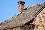 Defective chimney flashing, broken tiles, cracked mortar and missing gutter