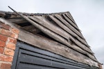 Garage with rustic warped wooden shingle gable end wall